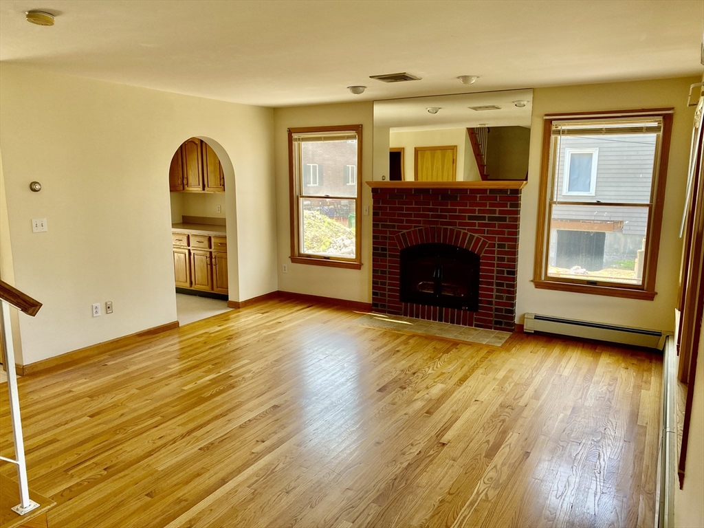 16 Centre Street, Unit 16 Roxbury, MA 02119 - Photo 12 of 14 a view of empty room with kitchen and fireplace