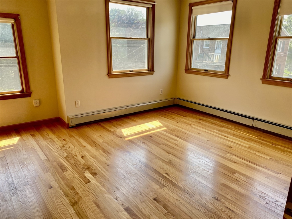 16 Centre Street, Unit 16 Roxbury, MA 02119 - Photo 13 of 14 a view of an empty room with wooden floor and a window