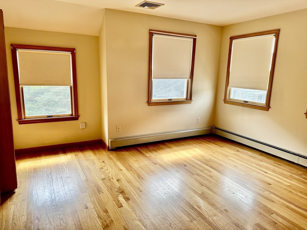 16 Centre Street, Unit 16 Roxbury, MA 02119 - Photo 3 of 14 a view of an empty room with wooden floor and a window