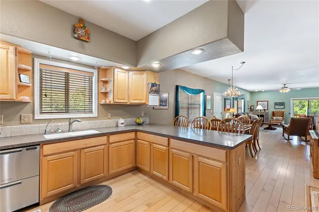 a kitchen with lots of counter space a sink a window and living room view