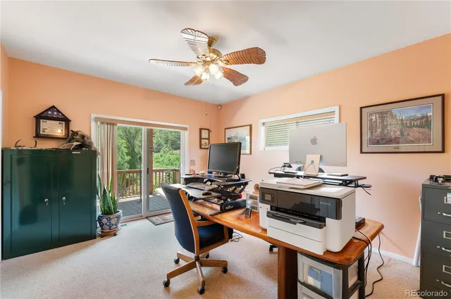 a view of a workspace with furniture and a window