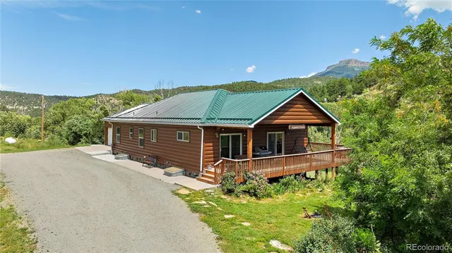 a front view of a house with yard and green space