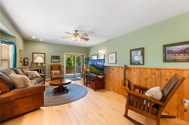 a living room with furniture kitchen view and a large window