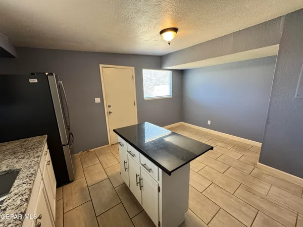 a kitchen with a stove a refrigerator and cabinets