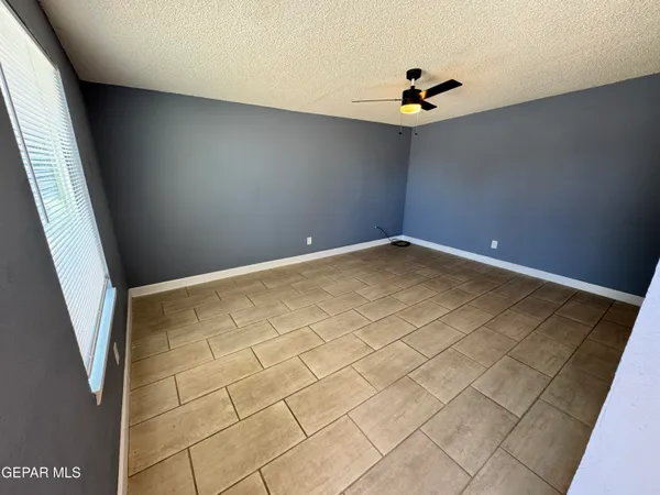 an empty room with windows and fan