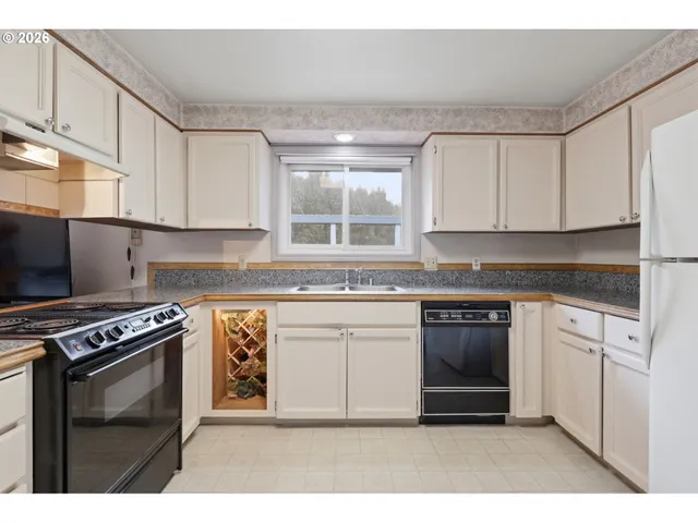 a kitchen with cabinets a stove and white appliances
