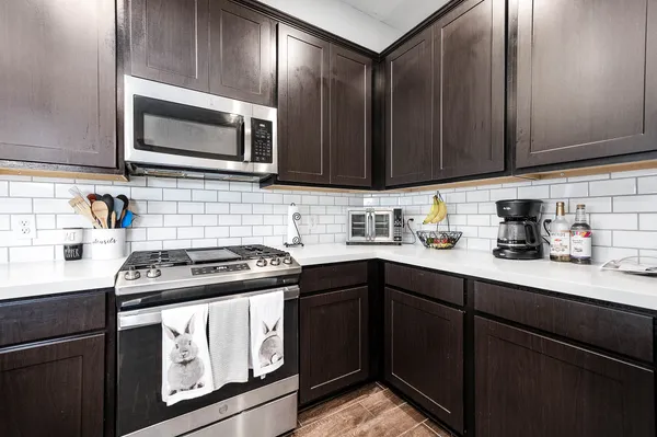 a kitchen with stainless steel appliances wooden cabinets and a stove top oven