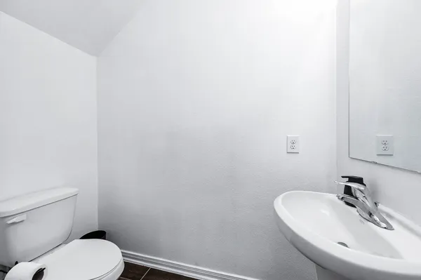 a bathroom with a toilet a sink and mirror