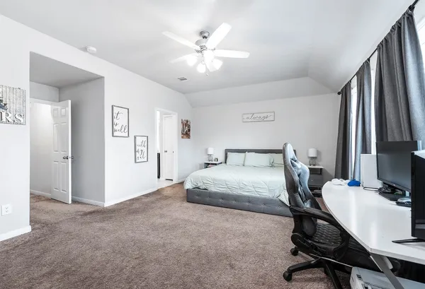 a bedroom with a bed desk and chair