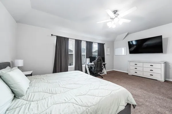a bedroom with a bed and a flat tv screen on wall
