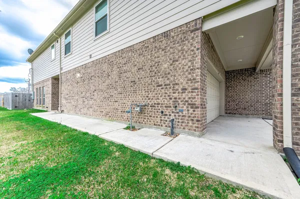 a view of a backyard with brick wall and a large tree