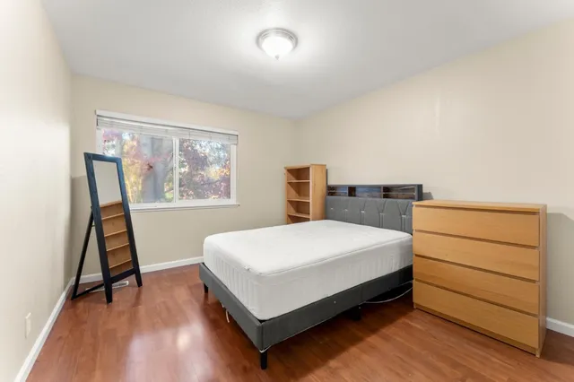 a bedroom with a bed and a painting on the wall