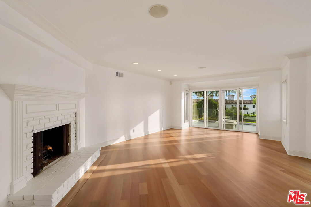 204 Tranquillo Road Pacific Palisades, CA 90272 - Photo 12 of 34 a view of an empty room with wooden floor fireplace and a window