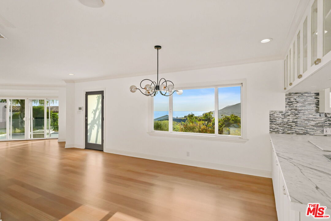 204 Tranquillo Road Pacific Palisades, CA 90272 - Photo 14 of 34 a view of an empty room with wooden floor and a window