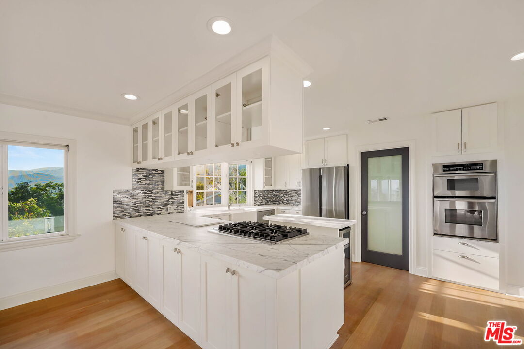 204 Tranquillo Road Pacific Palisades, CA 90272 - Photo 18 of 34 a kitchen with stainless steel appliances kitchen island granite countertop a stove and a refrigerator
