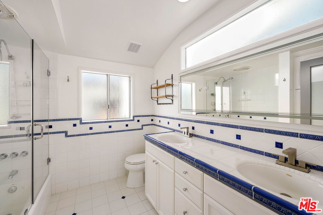204 Tranquillo Road Pacific Palisades, CA 90272 - Photo 30 of 34 a bathroom with a double vanity sink and mirror with toilet