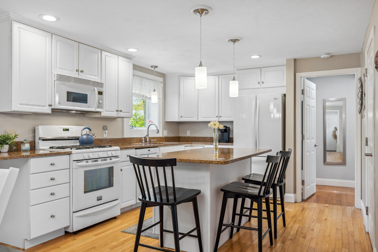 66 Nehoiden Road Mashpee, MA 02649 - Photo 5 of 32 a kitchen with white cabinets and stainless steel appliances