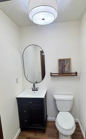 an empty room with wooden floor and ceiling fan