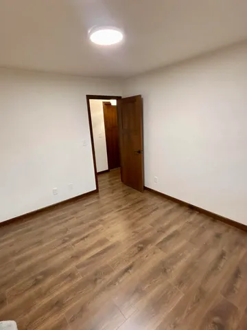 an empty room with wooden floor and window