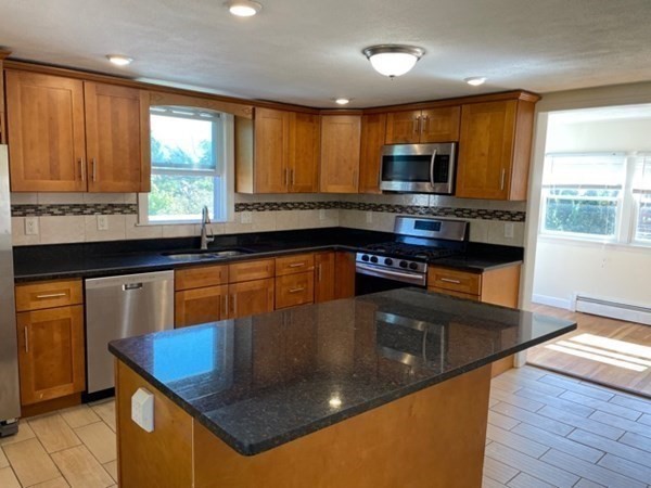 272-2 Nevada Street, Unit 2 Newton, MA 02460 - Photo 4 of 28 a kitchen with stainless steel appliances granite countertop a stove a sink and a microwave