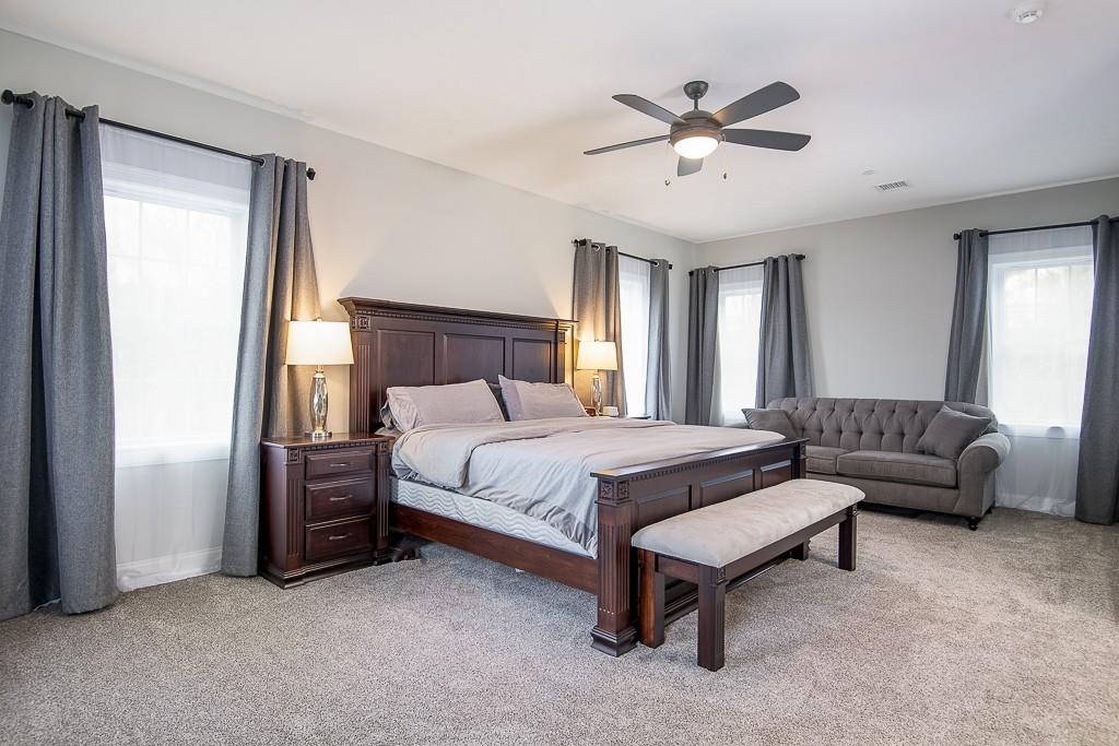 222 Sugar Road Bolton, MA 01740 - Photo 19 of 36 a spacious bedroom with a bed and a ceiling fan