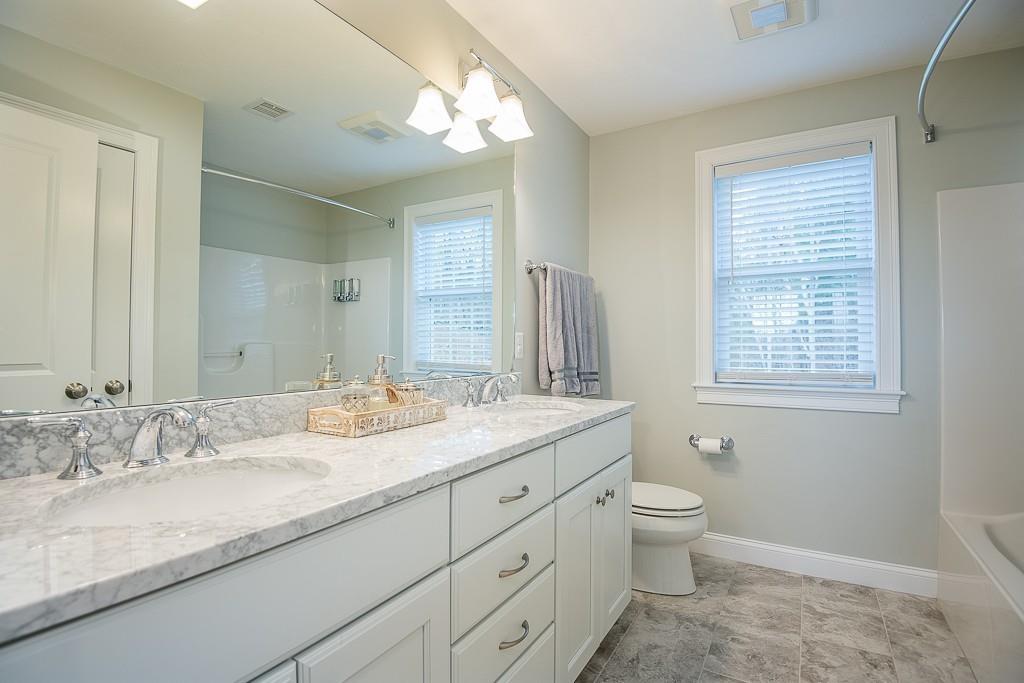222 Sugar Road Bolton, MA 01740 - Photo 26 of 36 a bathroom with a granite countertop double vanity sink a mirror and a toilet