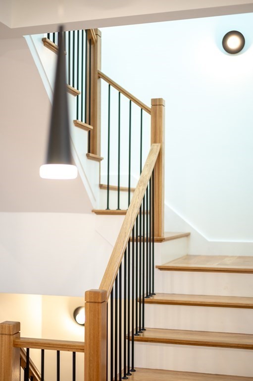 96 Otis Street, Unit 2 Cambridge, MA 02141 - Photo 21 of 42 a view of staircase with lots of frames on wall and a large window