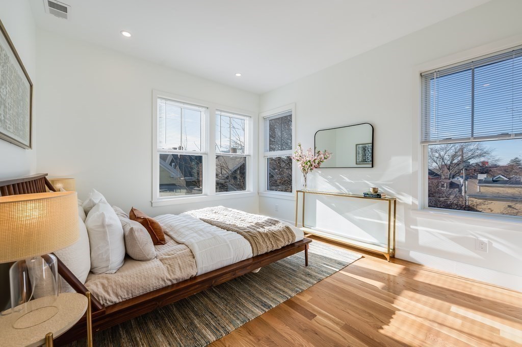 96 Otis Street, Unit 2 Cambridge, MA 02141 - Photo 23 of 42 a bedroom with a bed and wooden floor