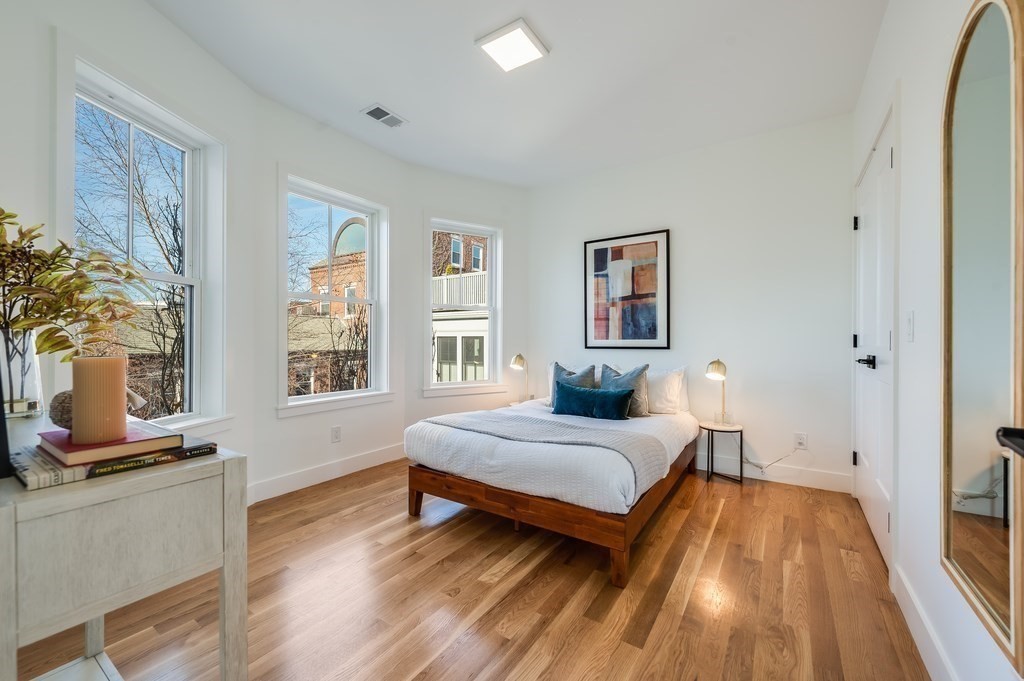 96 Otis Street, Unit 2 Cambridge, MA 02141 - Photo 28 of 42 a bedroom with a bed and wooden floor