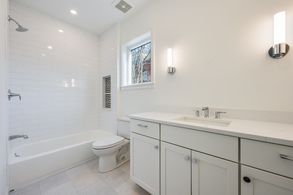 96 Otis Street, Unit 2 Cambridge, MA 02141 - Photo 29 of 42 a bathroom with a toilet a sink a mirror a bathtub and vanity