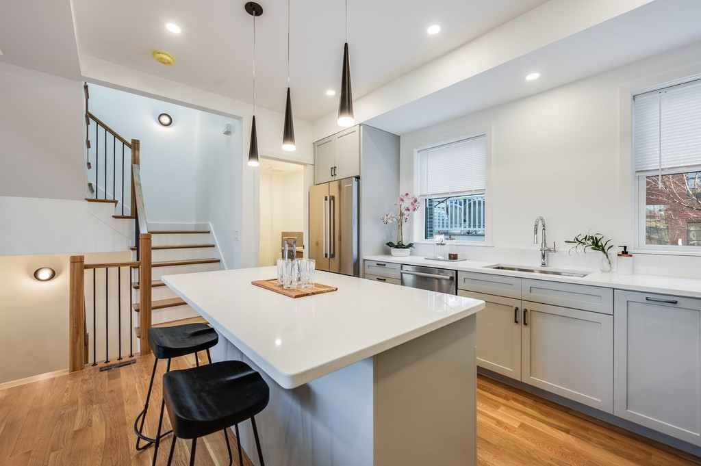 96 Otis Street, Unit 2 Cambridge, MA 02141 - Photo 7 of 42 a open kitchen with stainless steel appliances kitchen island a table chairs and wooden floor
