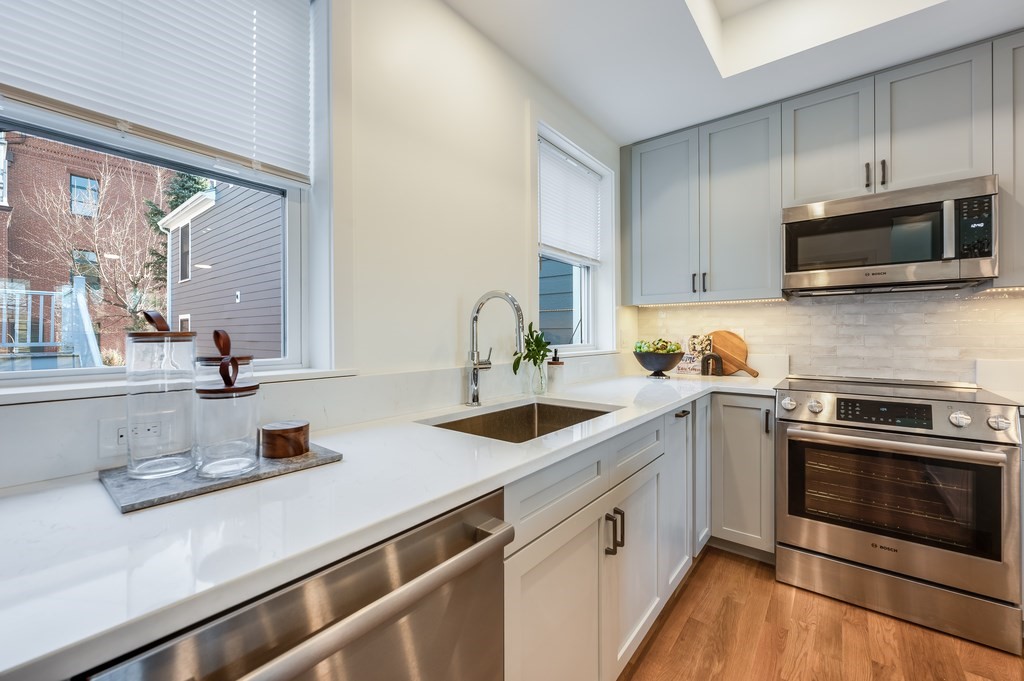 96 Otis Street, Unit 2 Cambridge, MA 02141 - Photo 9 of 42 a kitchen with cabinets a sink and stainless steel appliances