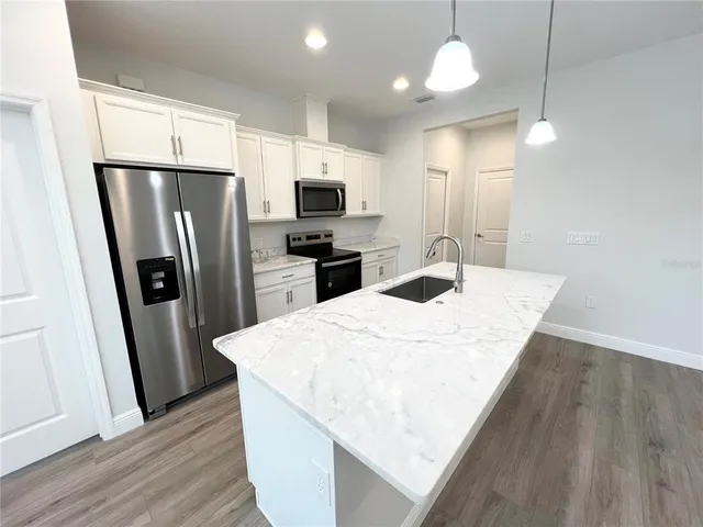 a kitchen with stainless steel appliances a refrigerator sink and microwave