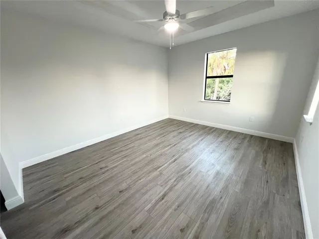 an empty room with windows and wooden floor