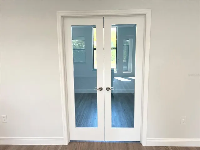 an empty room with wooden floor and a bathroom