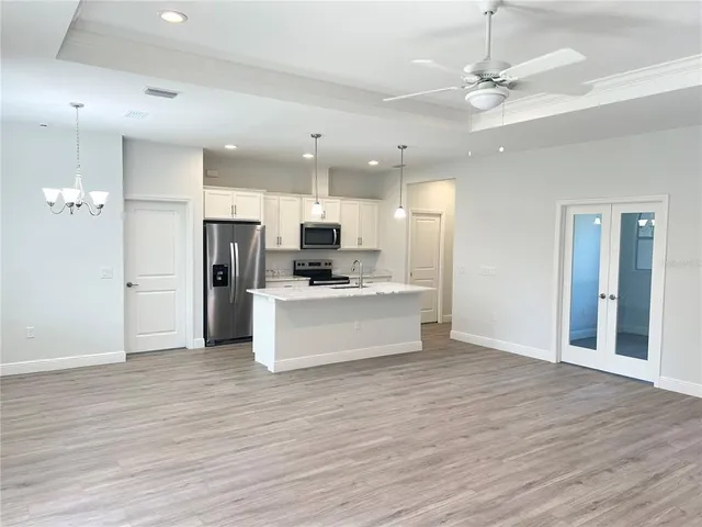 a view of kitchen with refrigerator cabinets and wooden floor