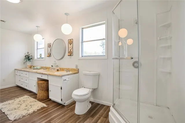a spacious bathroom with a double vanity sink a mirror and shower