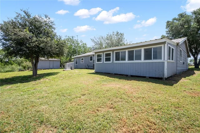 a front view of a house with yard and trees
