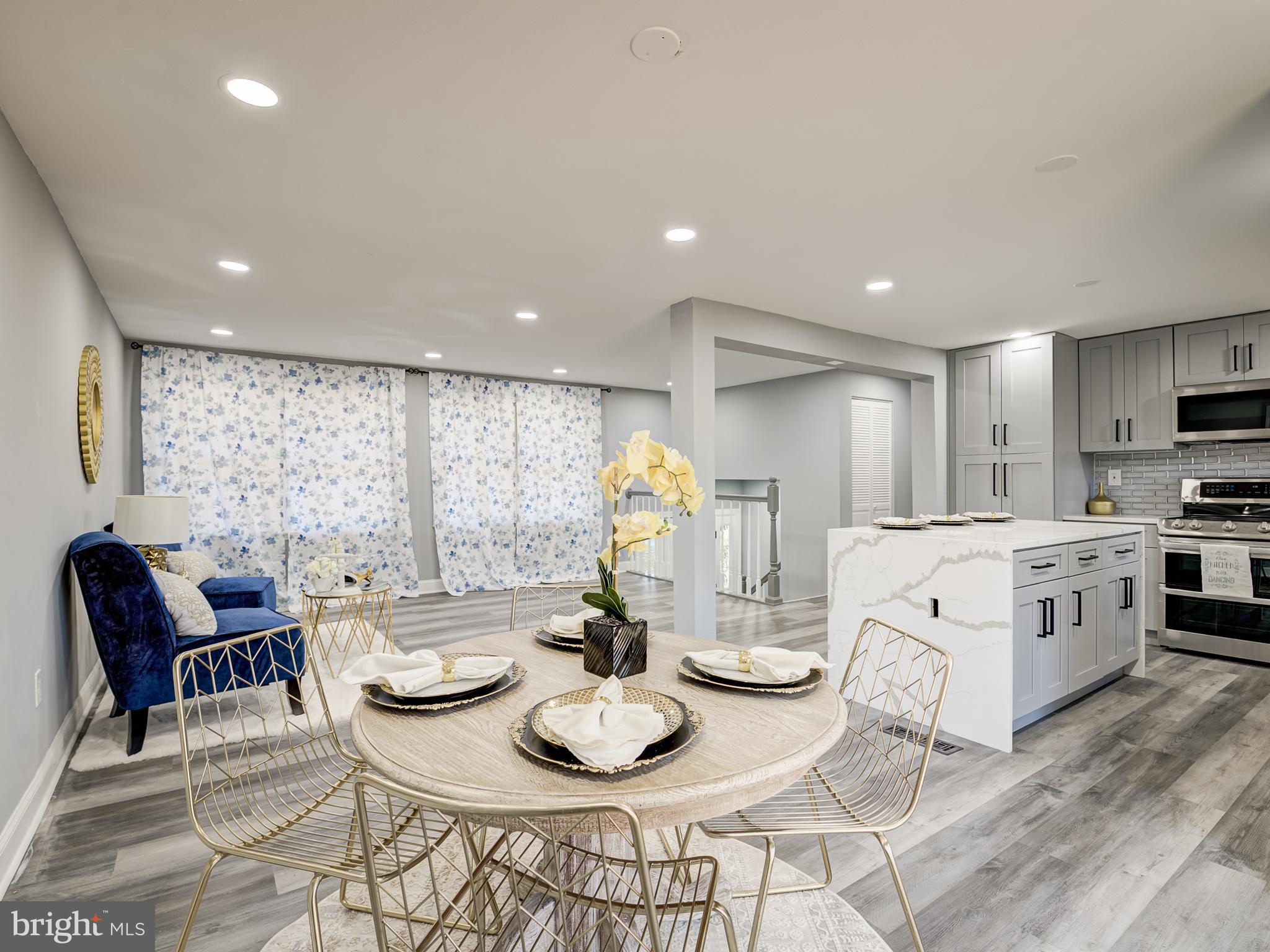 10814 Oldfield Drive Reston, VA 20191 - Photo 18 of 77 a kitchen with stainless steel appliances kitchen island granite countertop a table and chairs in it