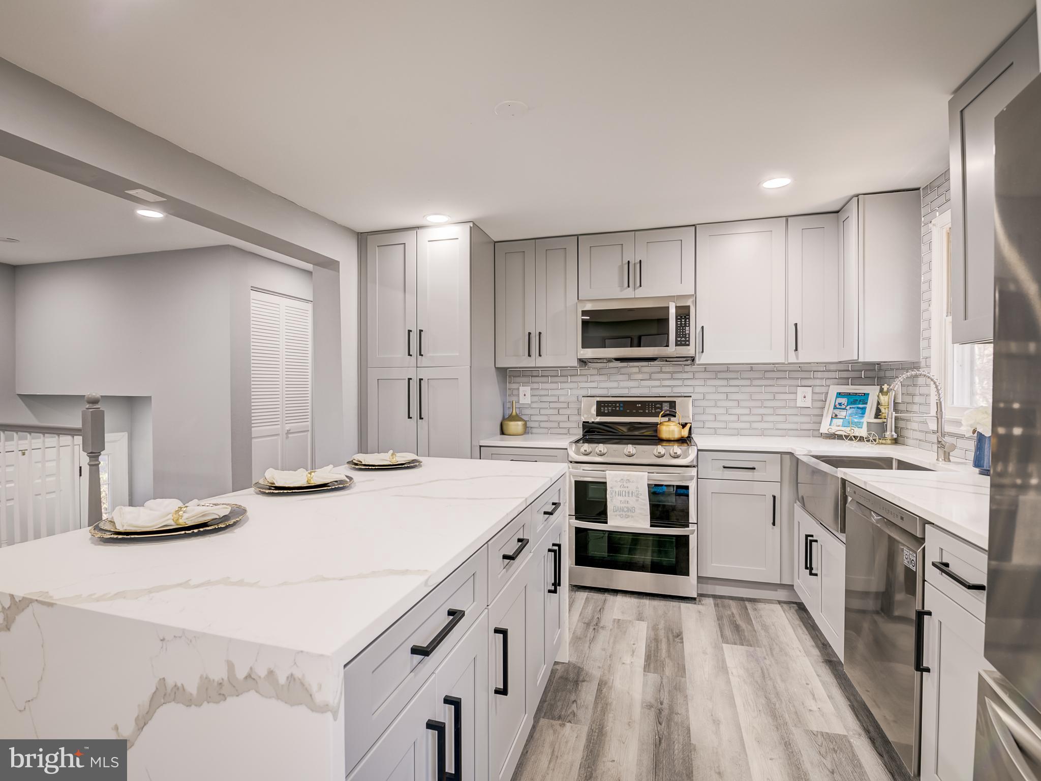 10814 Oldfield Drive Reston, VA 20191 - Photo 20 of 77 a kitchen with granite countertop a stove top oven sink and cabinets