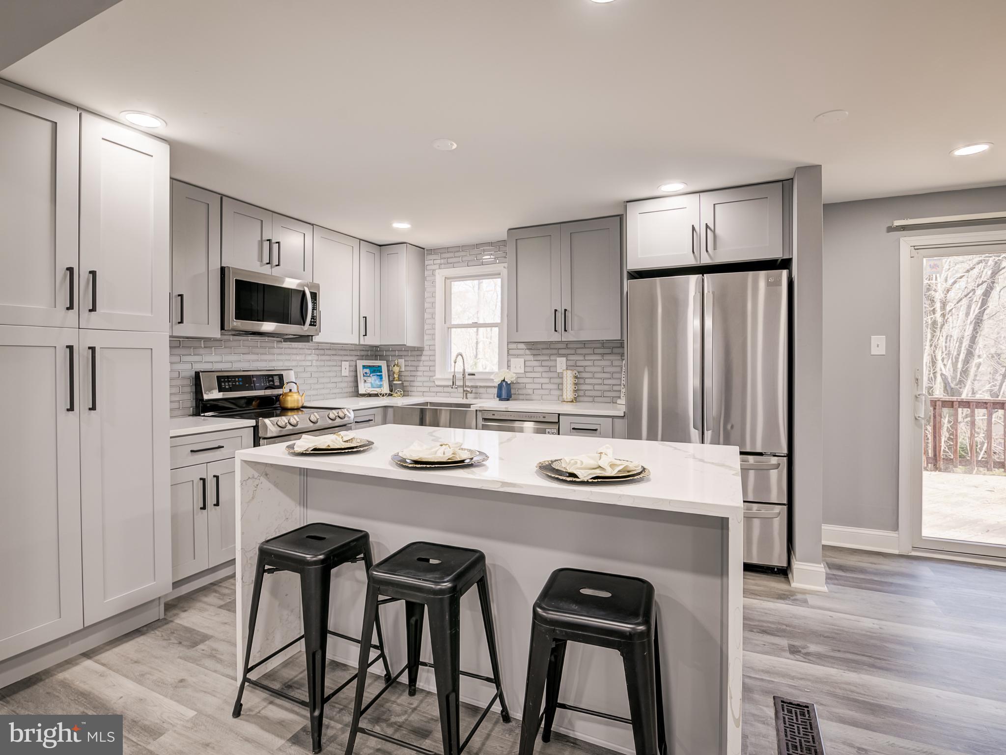 10814 Oldfield Drive Reston, VA 20191 - Photo 22 of 77 a kitchen with stainless steel appliances granite countertop a stove a refrigerator a microwave a sink and white cabinets