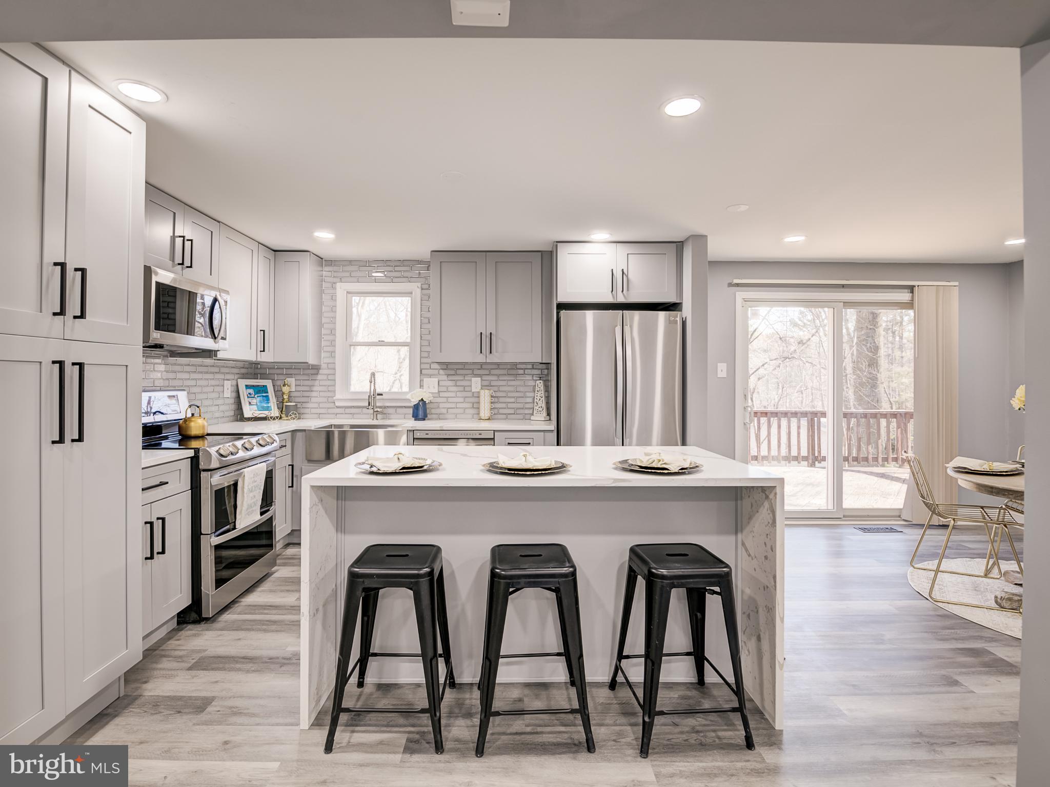 10814 Oldfield Drive Reston, VA 20191 - Photo 23 of 77 a kitchen with stainless steel appliances granite countertop a stove a refrigerator a sink a dining table and chairs