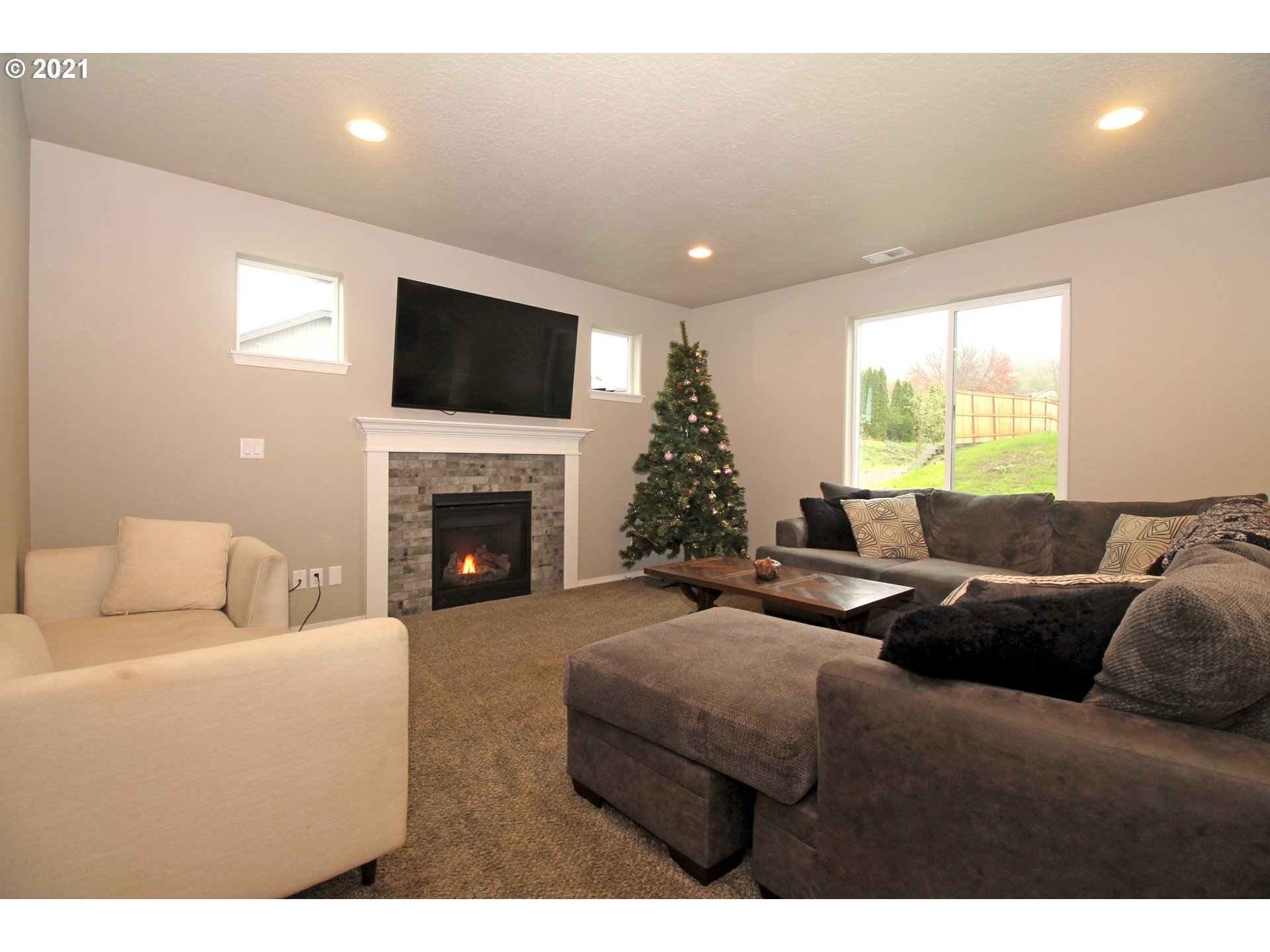 2041 South 59th Street Springfield, OR 97478 - Photo 4 of 31 a living room with furniture a flat screen tv and a fireplace