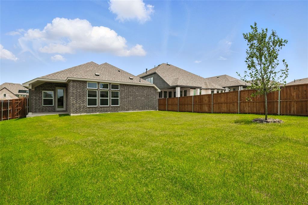530 Red Barn Drive Van Alstyne, TX 75495 - Photo 25 of 40 Rear view of house with a fenced backyard, brick siding, and roof with shingles