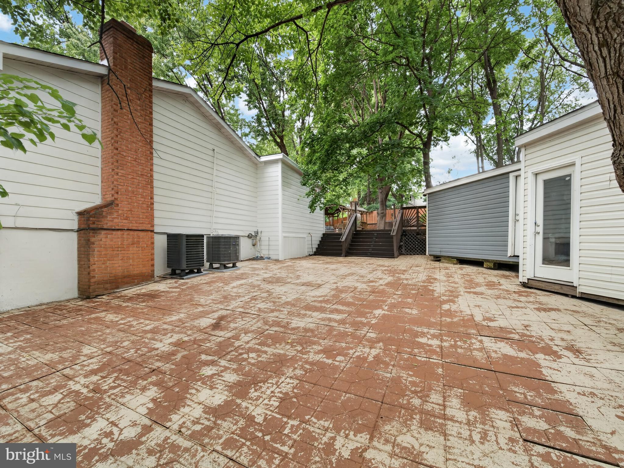 13427 Delaney Road Woodbridge, VA 22193 - Photo 57 of 57 a backyard of a house with large trees and brick wall