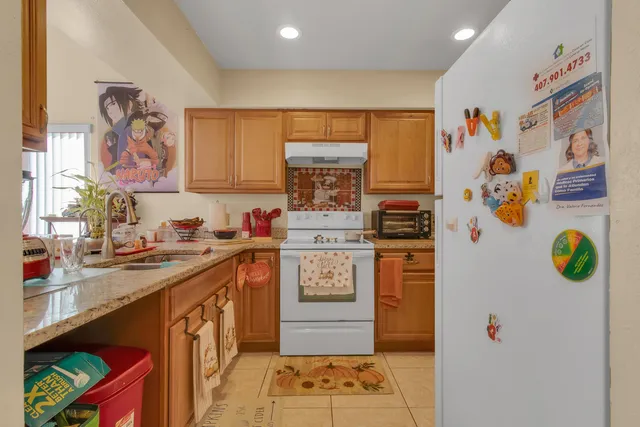 a kitchen with granite countertop lots of clutter and stainless steel appliances