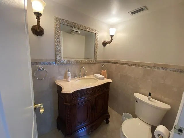 a bathroom with a toilet sink and mirror