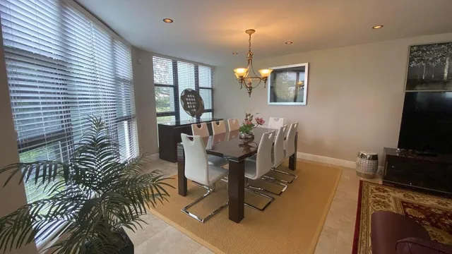 a view of a dining room with furniture a chandelier and wooden floor