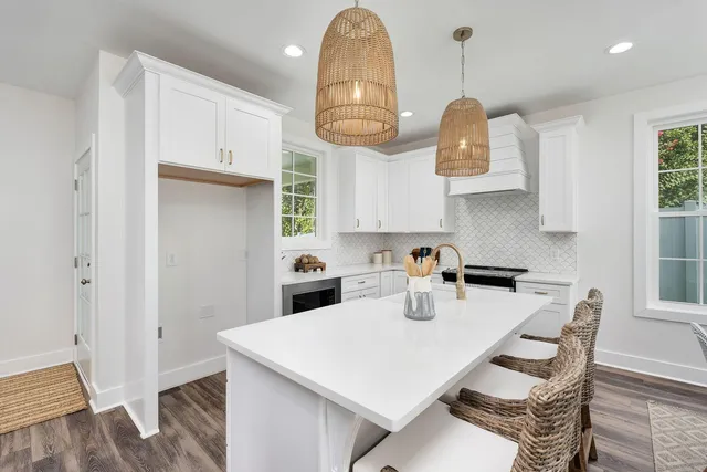 a kitchen with stainless steel appliances granite countertop a sink a stove and a wooden floors