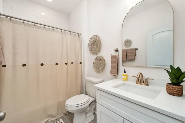 a bathroom with a sink a toilet and a mirror